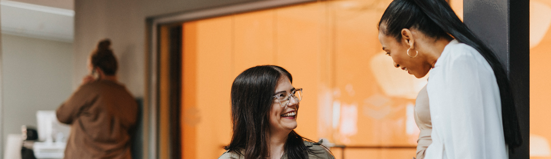 Colleagues smiling and talking at work  